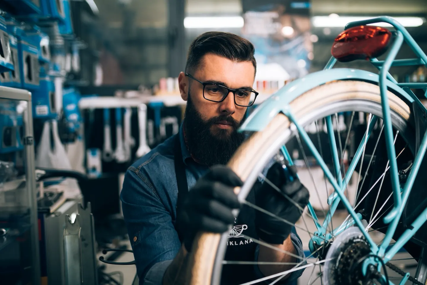 Bicycle repair shop owner works on a tire.