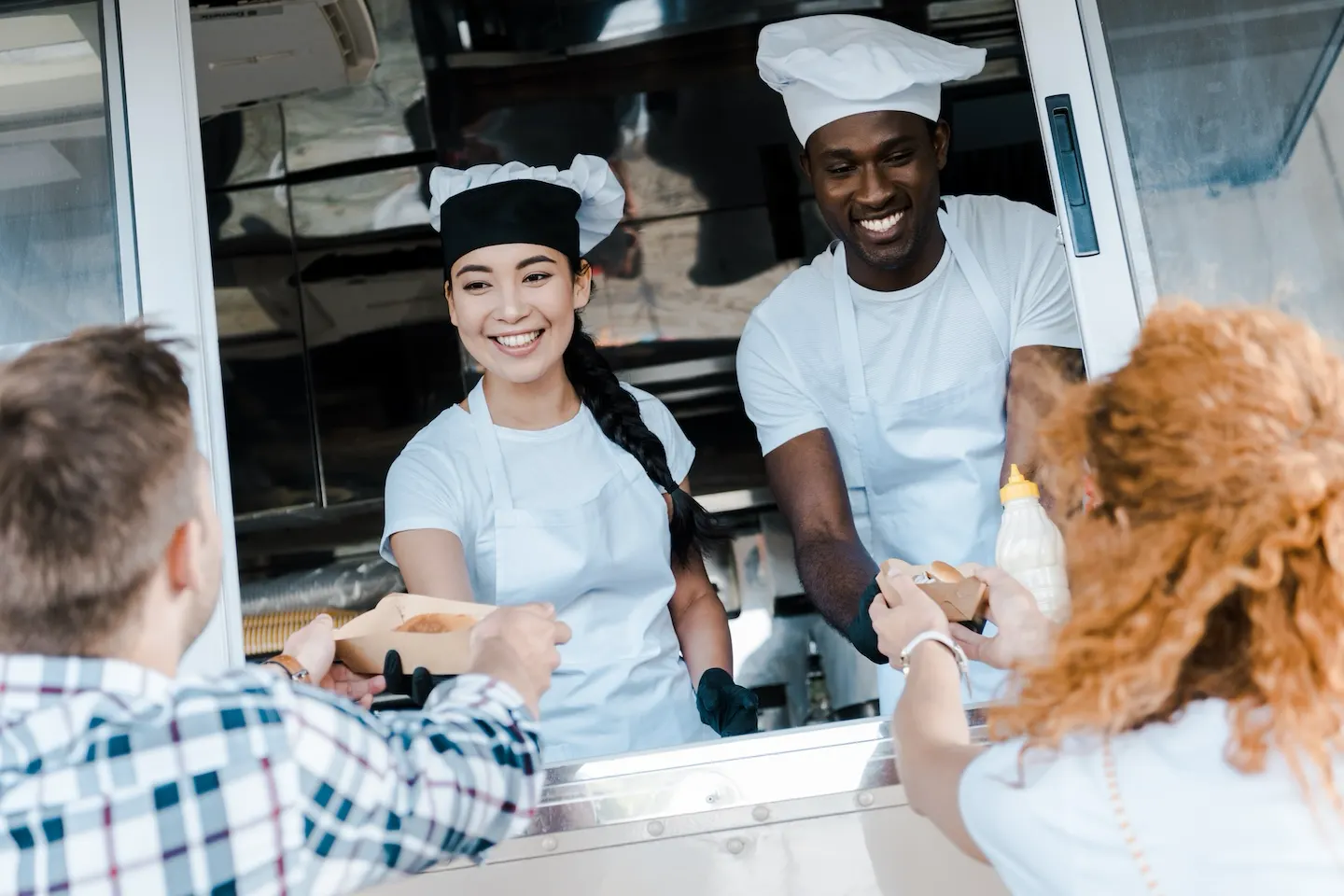 Food truck chefs serve food to customers.